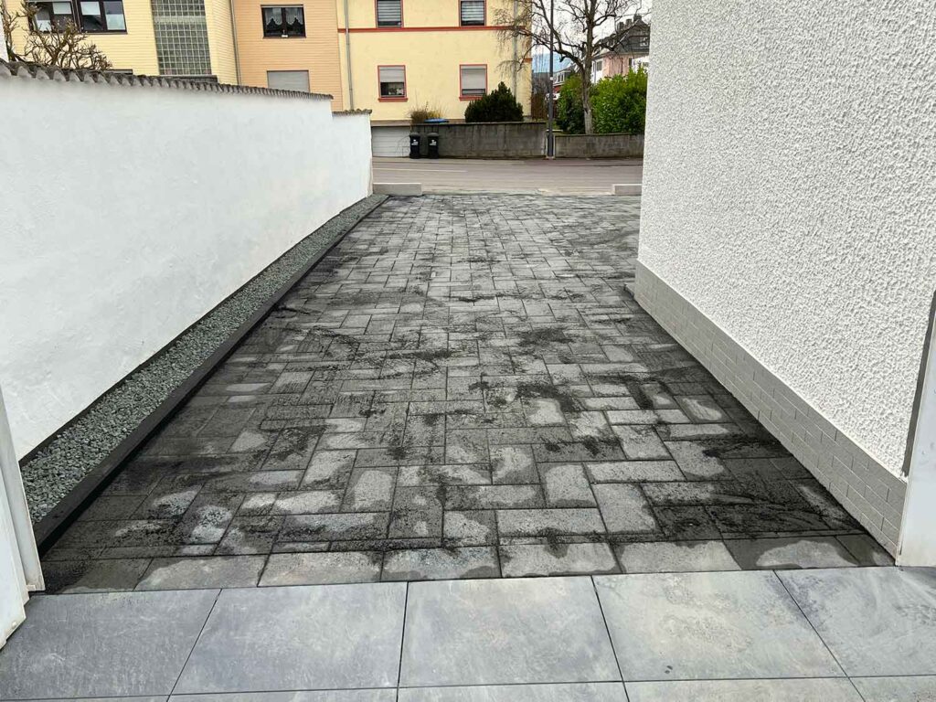 großer gepflasterter Bereich vor einem Mehrfamilienhaus