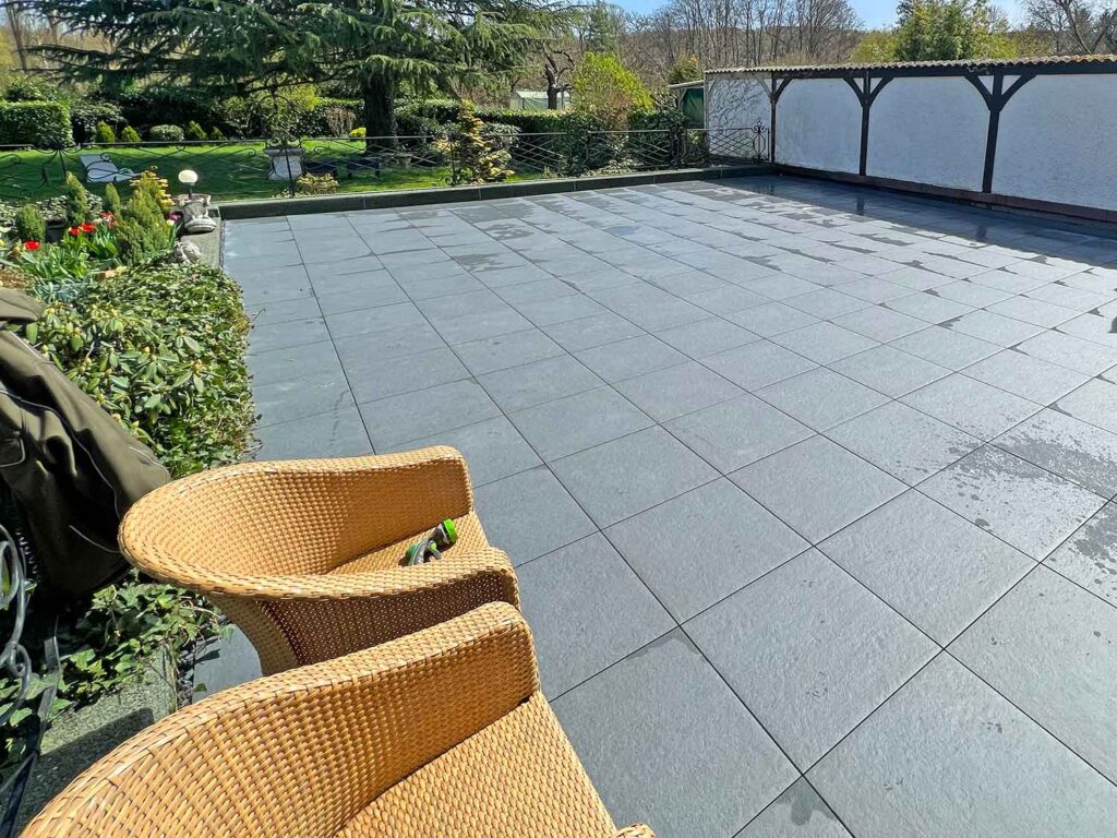 Terrasse aus Betonplatten in einem herbstlichen Garten