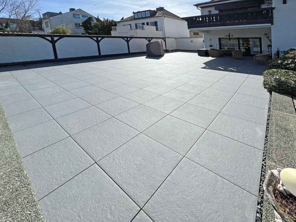Terrasse aus Betonplatten in einem herbstlichen Garten