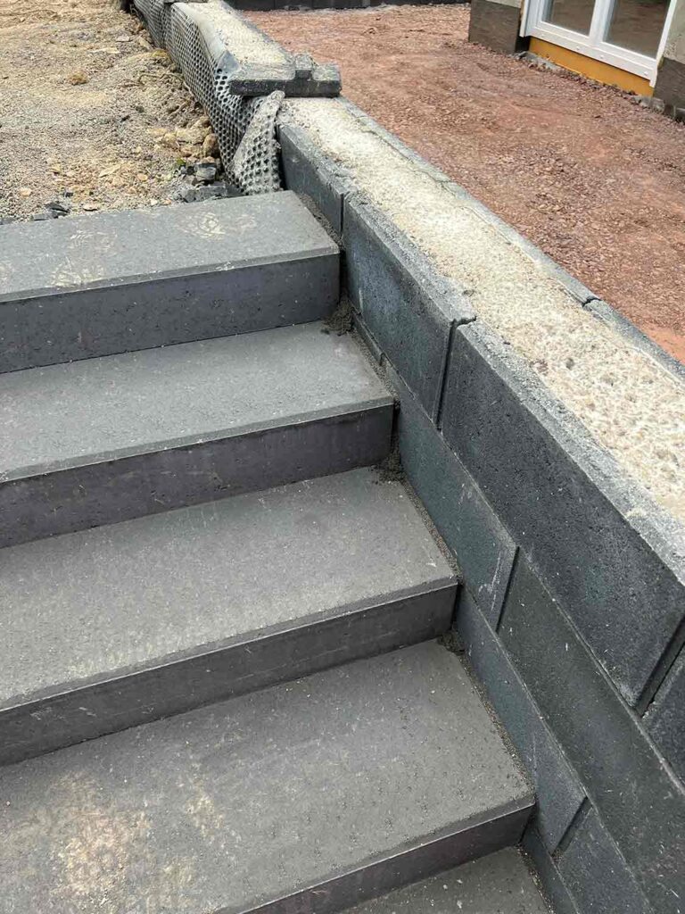 unfertige Treppe im Garten mit neu gesetzter Mauer
