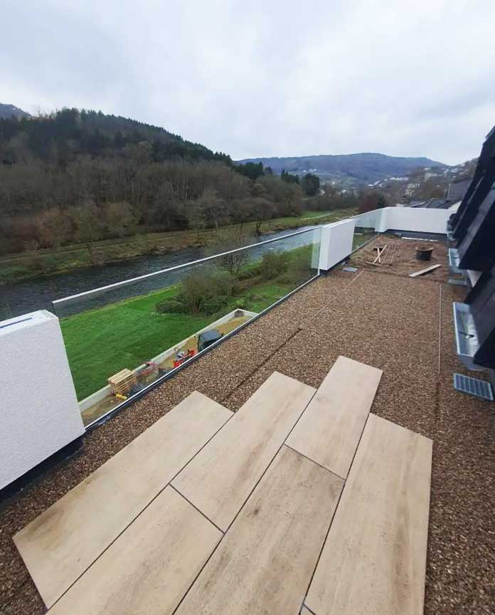 Arbeitsschritt in einer Terrassen-Erneuerung: Platten werden auf dem vorbereiteten Untergrund ausgelegt