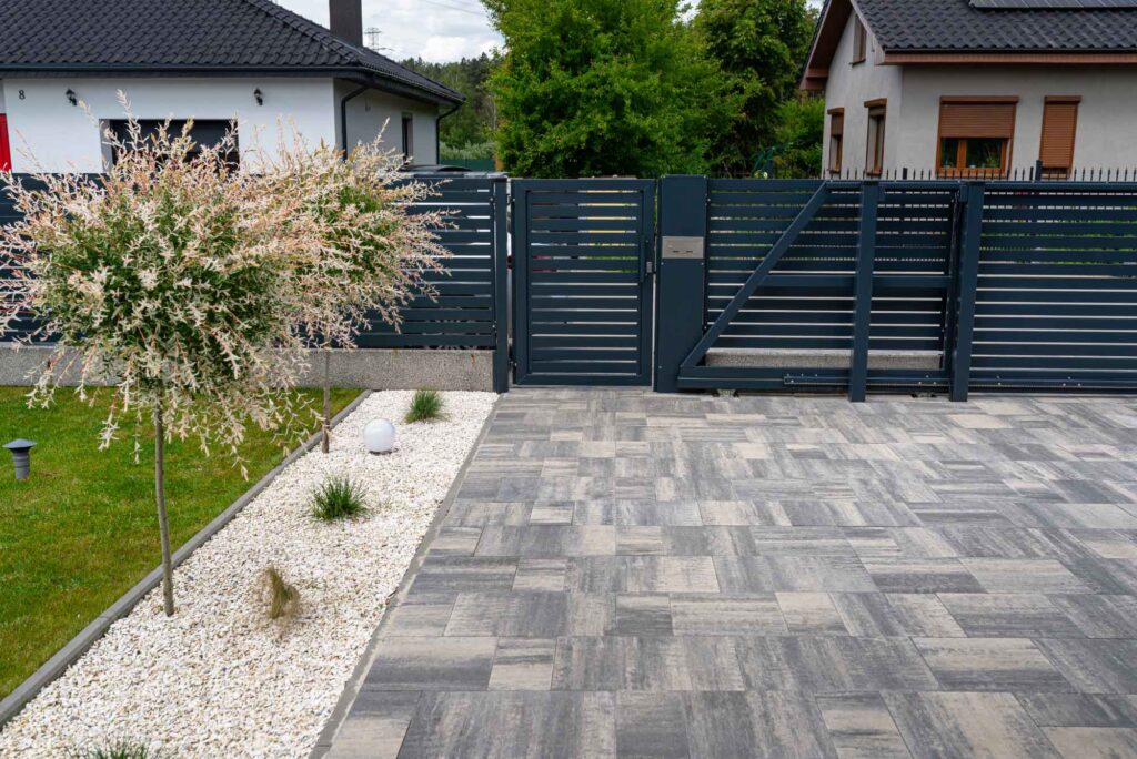 Hof in einem schön angelegten Garten mit automatischem Tor und Sichtschutz