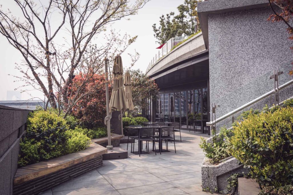 Terrasse eines Gastronomie-Betriebes mit Mäuerchen und Bepflanzung